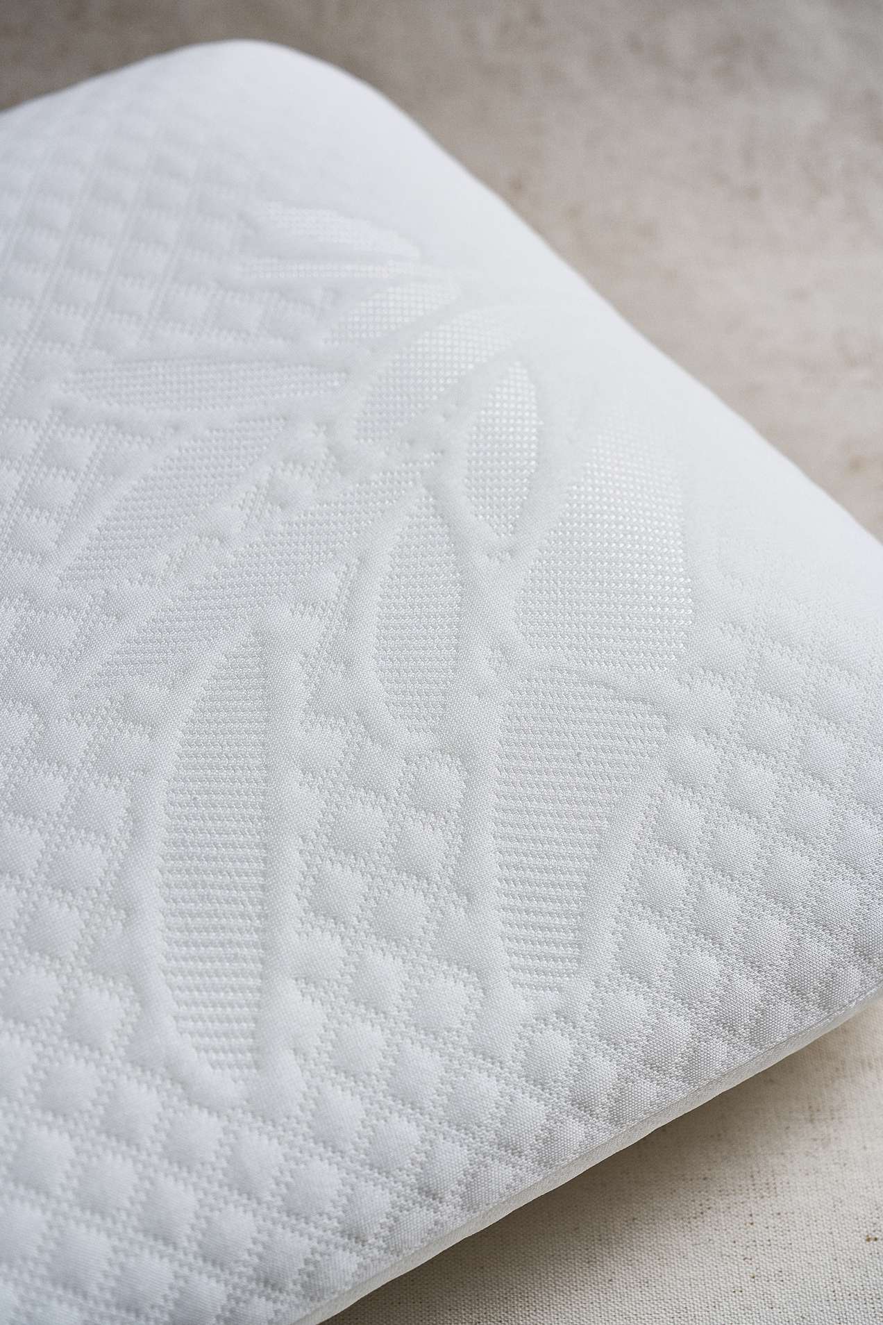Almohada Plumax de memory foam con funda texturizada, para soporte ergonómico y confort superior.