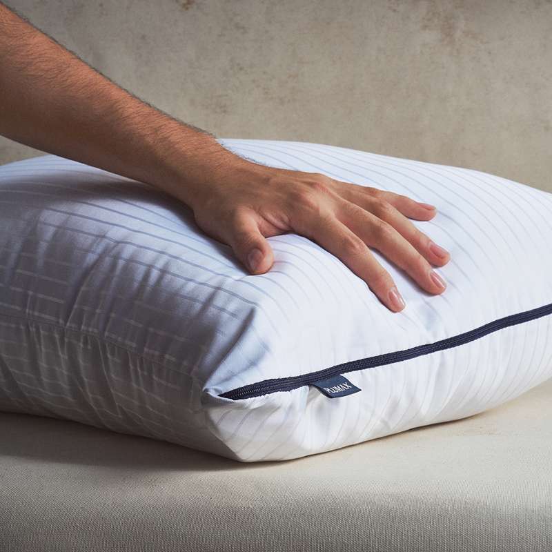Almohada Plumax de lujo con tejido de satén a rayas, proporcionando un tacto sedoso y un soporte confortable.