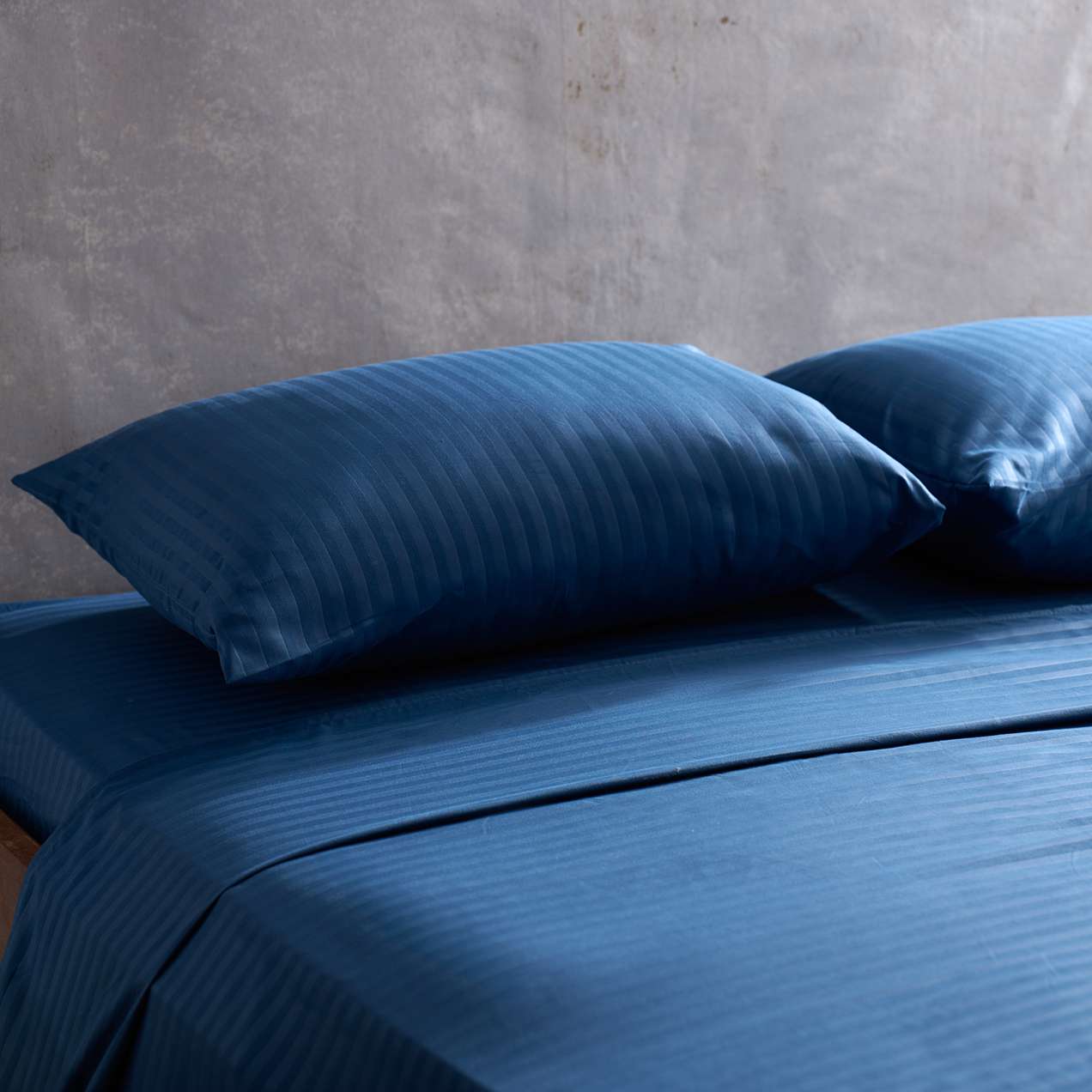 Sábana Plumax de algodón premium en color azul oscuro, ofreciendo una experiencia de sueño lujosa y envolvente.