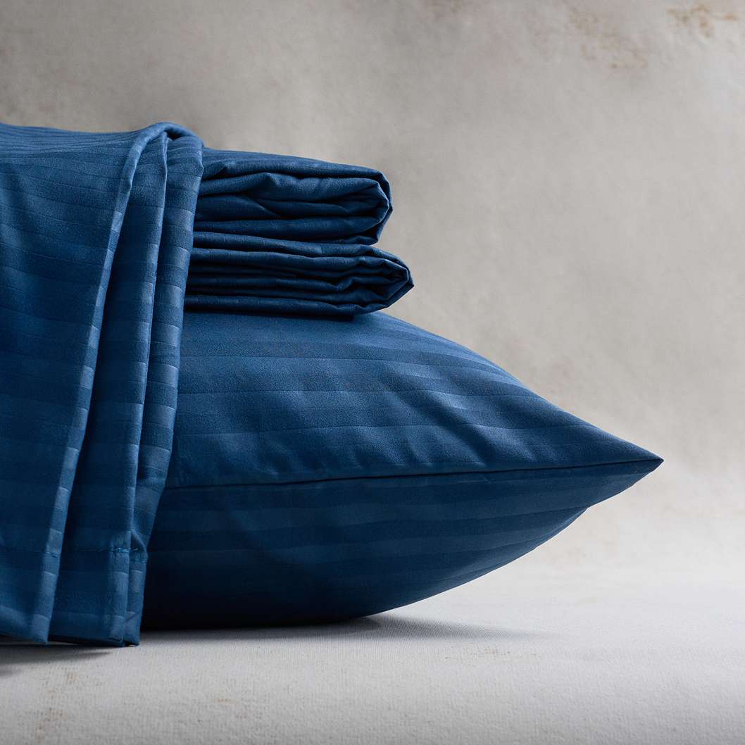 Sábana Plumax azul oscura ultra suave y confortable, ideal para un descanso profundo y una decoración moderna.