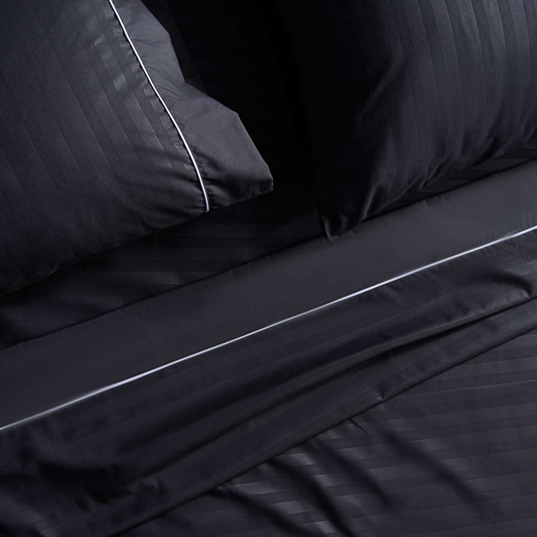 Sábana Plumax de algodón premium en color negro, ofreciendo una experiencia de sueño lujosa y envolvente.
